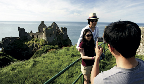 Pessoas tirando foto no Dunluce Castle, na Irlanda do Norte