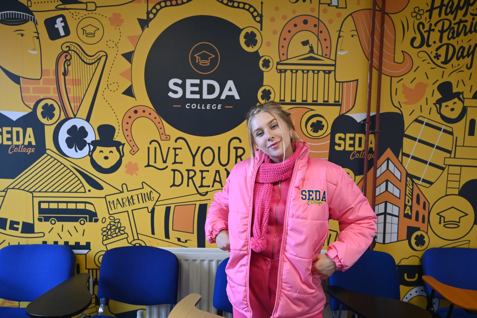 Student beside the SEDA College mural in Dublin